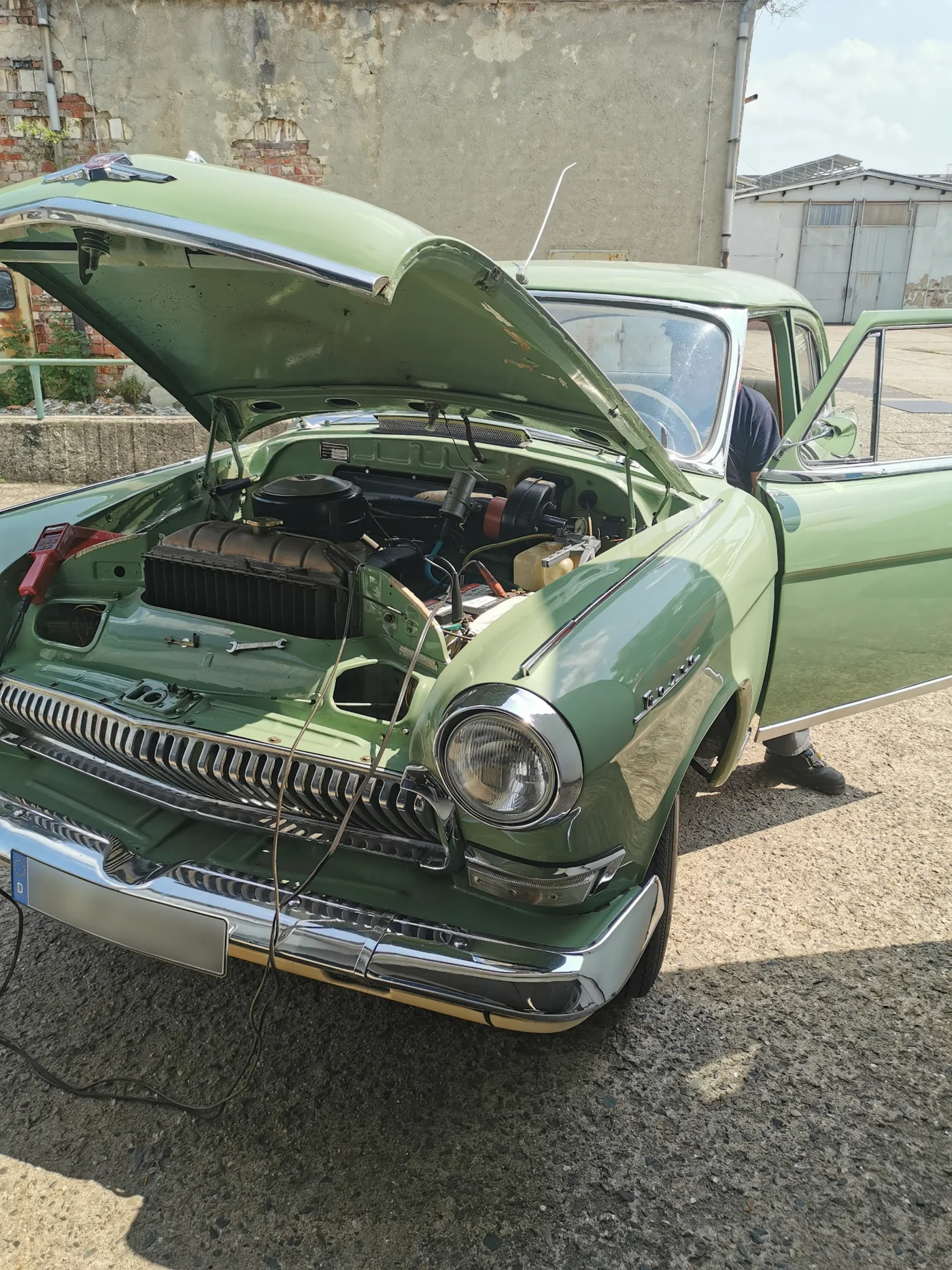 Grüner Oldtimer mit geöffneter Motorhaube